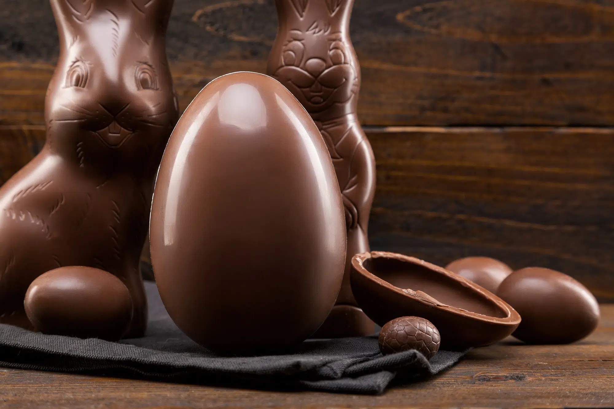 Chocolate Easter bunny, eggs and sweets on rustic background