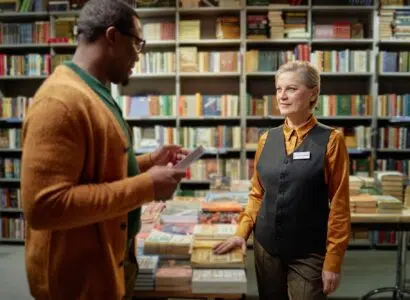 Middle Aged Caucasian Woman Assisting Young Black Man in Bookstore