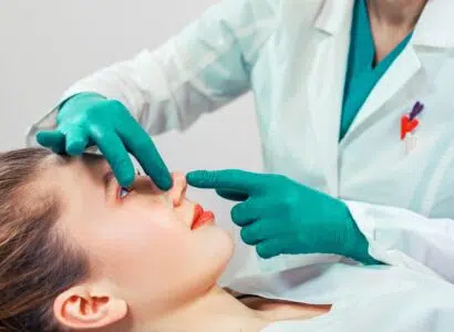 Rhinoplasty, the surgeon hands touches the patient s nose. People, cosmetology, plastic surgery and