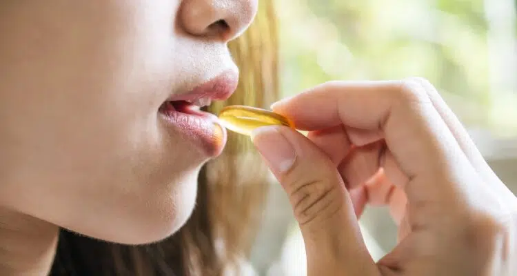 Young woman taking medicine pill after doctor order